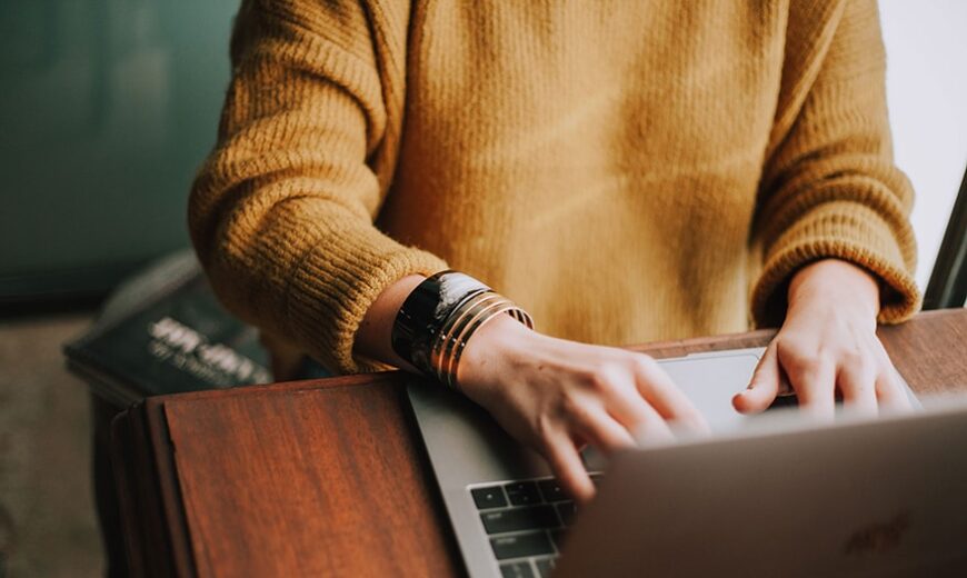 Woman's hands typing on a laptop
